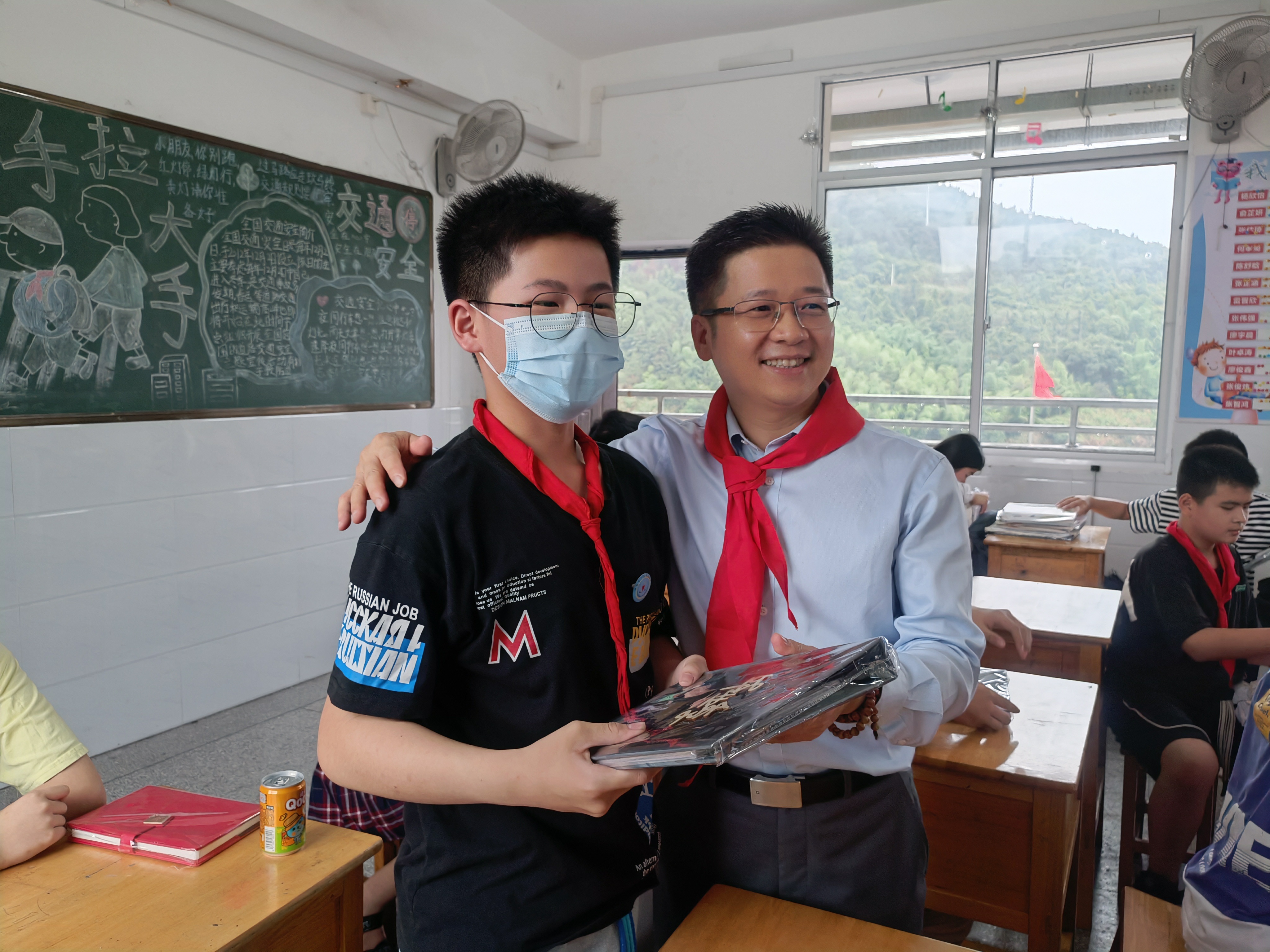 图为同方全球人寿福建分公司总经理叶锦发先生分发毕业纪念册与小同学留影.jpg