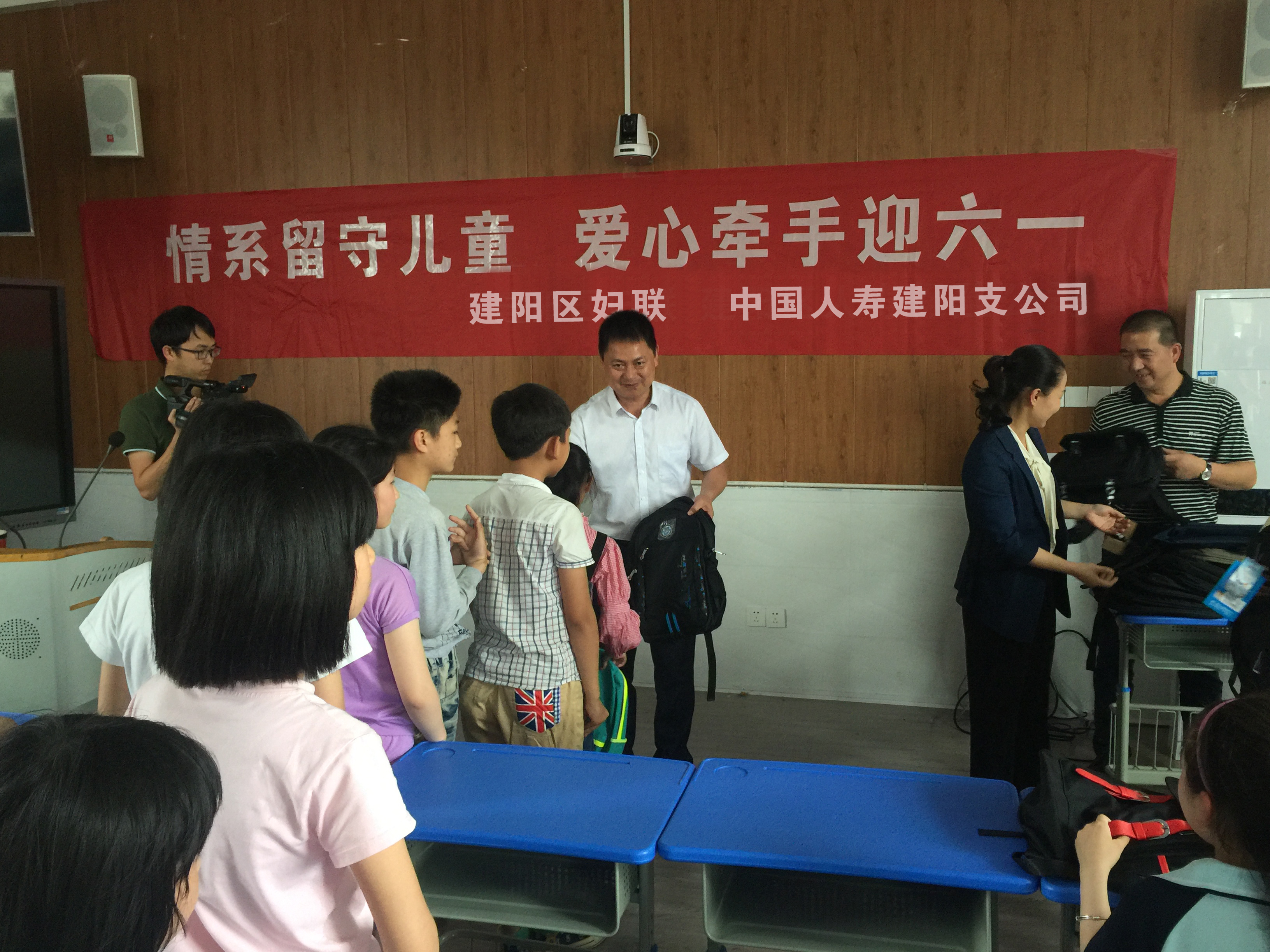 图为公司副经理郑顺阳给孩子们送上学习用品的场景.jpg